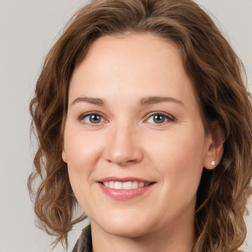 Joyful white young-adult female with medium  brown hair and green eyes