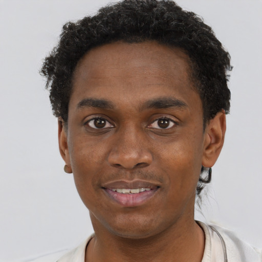 Joyful black young-adult male with short  brown hair and brown eyes