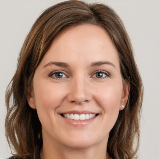 Joyful white young-adult female with long  brown hair and grey eyes