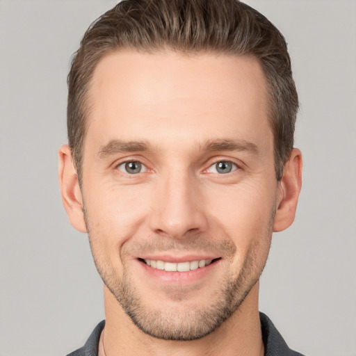 Joyful white young-adult male with short  brown hair and grey eyes