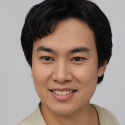 Joyful asian young-adult male with short  brown hair and brown eyes