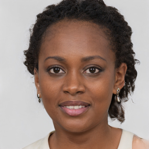 Joyful black young-adult female with long  brown hair and brown eyes
