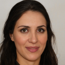 Joyful white adult female with long  brown hair and brown eyes