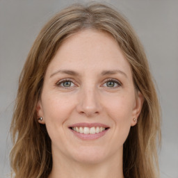 Joyful white young-adult female with medium  brown hair and green eyes