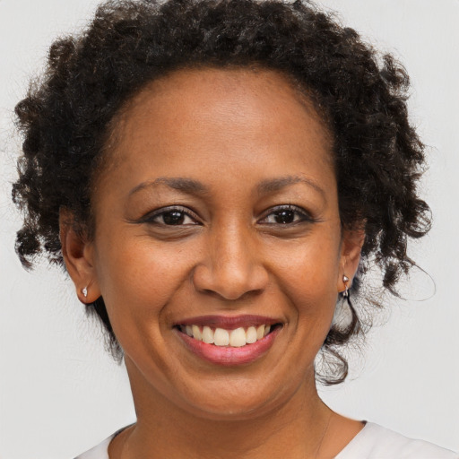 Joyful black adult female with short  brown hair and brown eyes