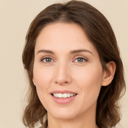 Joyful white young-adult female with long  brown hair and green eyes