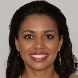 Joyful black young-adult female with long  brown hair and brown eyes