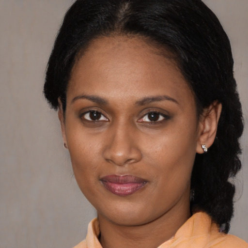 Joyful black adult female with medium  brown hair and brown eyes