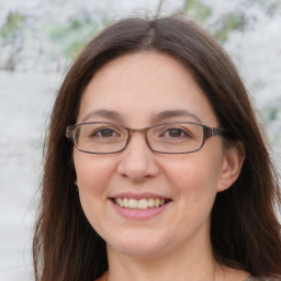 Joyful white adult female with long  brown hair and grey eyes