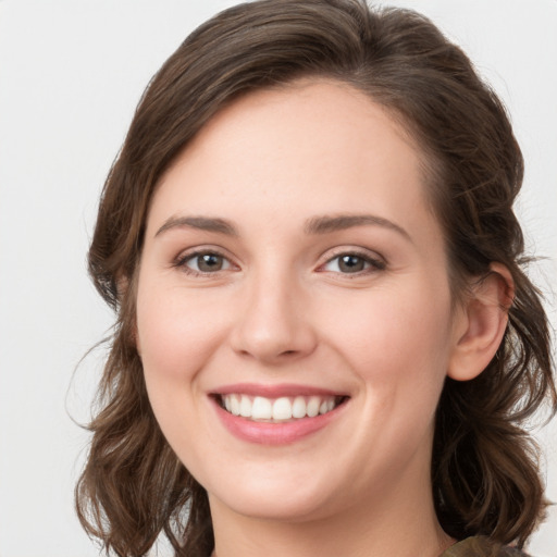 Joyful white young-adult female with long  brown hair and grey eyes