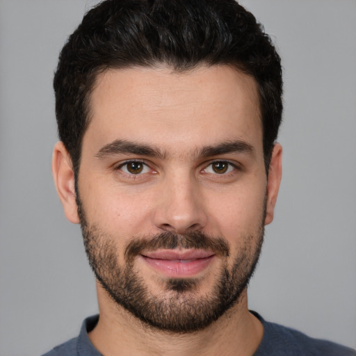 Joyful white young-adult male with short  black hair and brown eyes