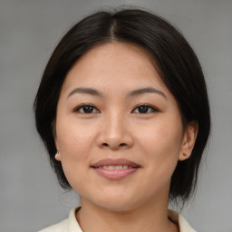 Joyful asian young-adult female with medium  brown hair and brown eyes