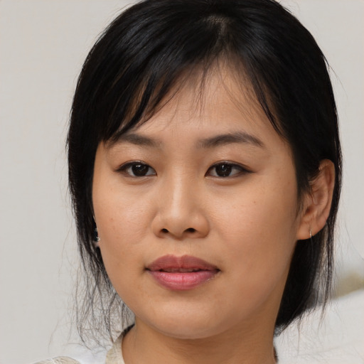 Joyful asian young-adult female with medium  black hair and brown eyes
