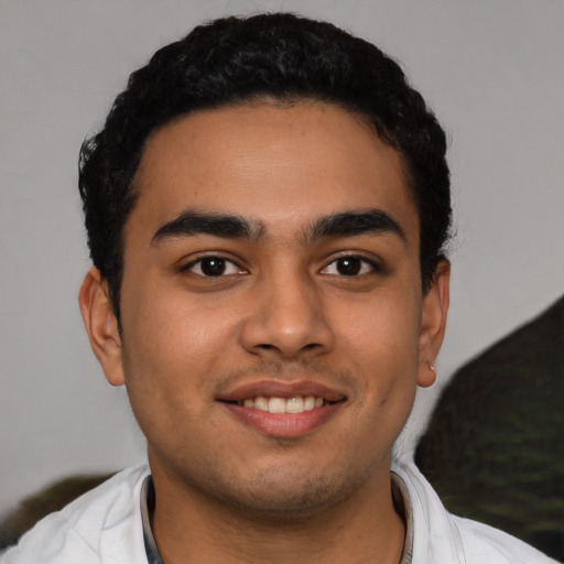 Joyful latino young-adult male with short  black hair and brown eyes