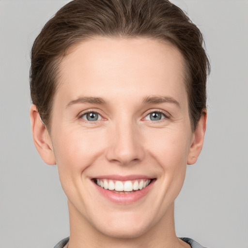 Joyful white young-adult female with short  brown hair and grey eyes