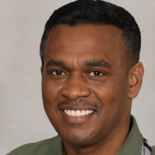 Joyful black young-adult male with short  black hair and brown eyes