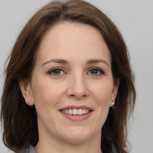 Joyful white adult female with medium  brown hair and brown eyes