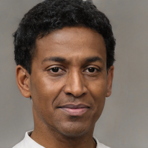 Joyful black young-adult male with short  black hair and brown eyes