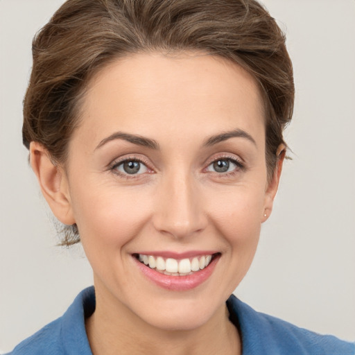 Joyful white young-adult female with short  brown hair and grey eyes