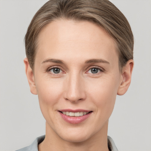 Joyful white young-adult female with short  brown hair and grey eyes