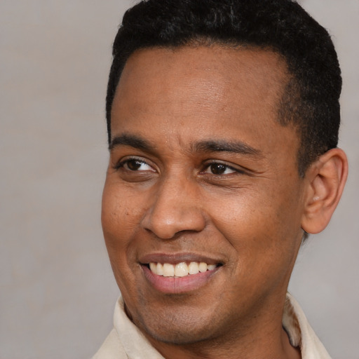 Joyful latino adult male with short  brown hair and brown eyes
