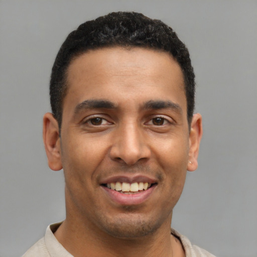 Joyful latino young-adult male with short  brown hair and brown eyes
