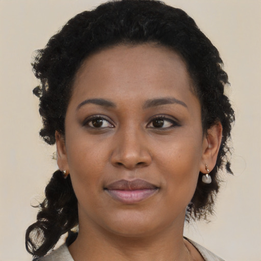 Joyful black young-adult female with medium  brown hair and brown eyes