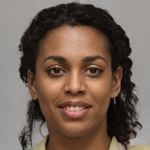 Joyful black young-adult female with medium  brown hair and brown eyes