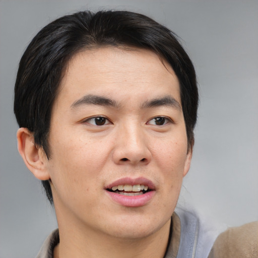 Joyful asian young-adult male with short  brown hair and brown eyes