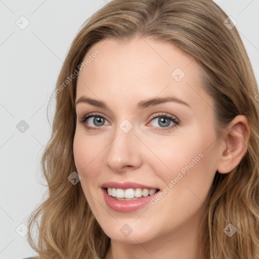 Joyful white young-adult female with long  brown hair and blue eyes