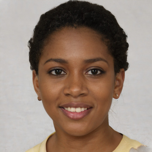 Joyful black young-adult female with short  brown hair and brown eyes