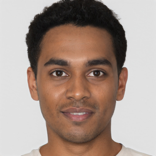 Joyful black young-adult male with short  black hair and brown eyes