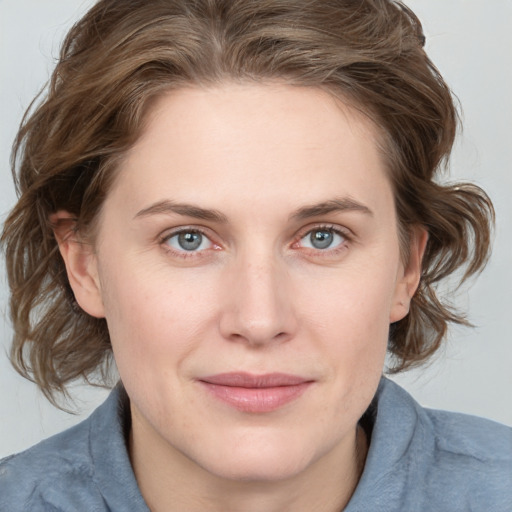 Joyful white young-adult female with medium  brown hair and blue eyes