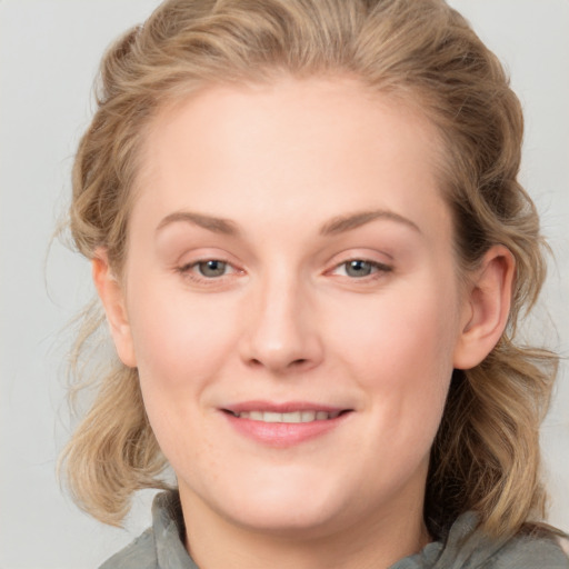 Joyful white young-adult female with medium  brown hair and blue eyes