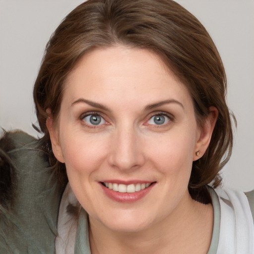 Joyful white young-adult female with medium  brown hair and blue eyes