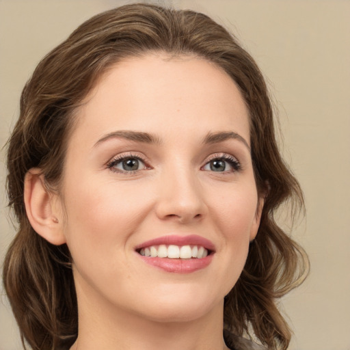 Joyful white young-adult female with medium  brown hair and green eyes