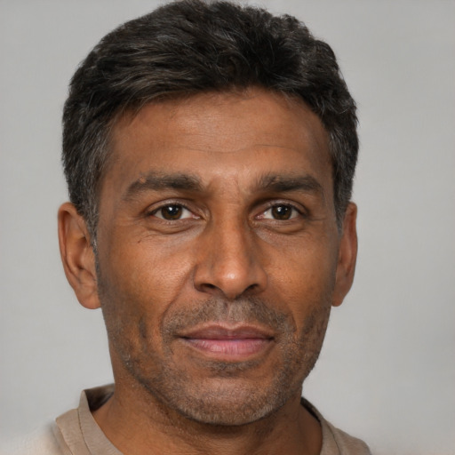Joyful black adult male with short  brown hair and brown eyes