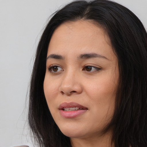 Joyful asian young-adult female with long  brown hair and brown eyes