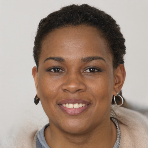 Joyful black young-adult female with short  brown hair and brown eyes