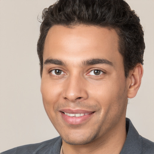 Joyful white young-adult male with short  black hair and brown eyes