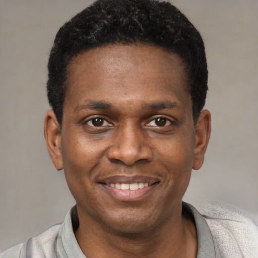 Joyful black young-adult male with short  black hair and brown eyes