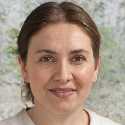 Joyful white adult female with medium  brown hair and grey eyes