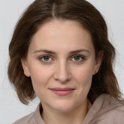 Joyful white young-adult female with medium  brown hair and grey eyes