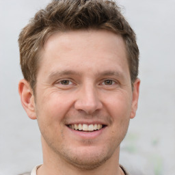 Joyful white adult male with short  brown hair and grey eyes