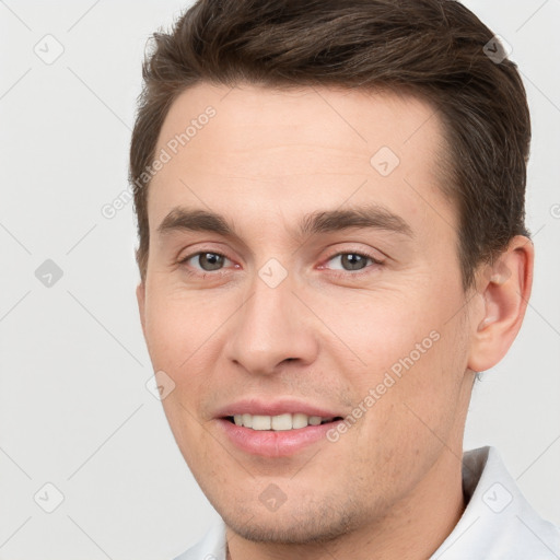 Joyful white young-adult male with short  brown hair and brown eyes