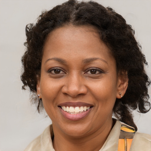 Joyful black adult female with medium  brown hair and brown eyes