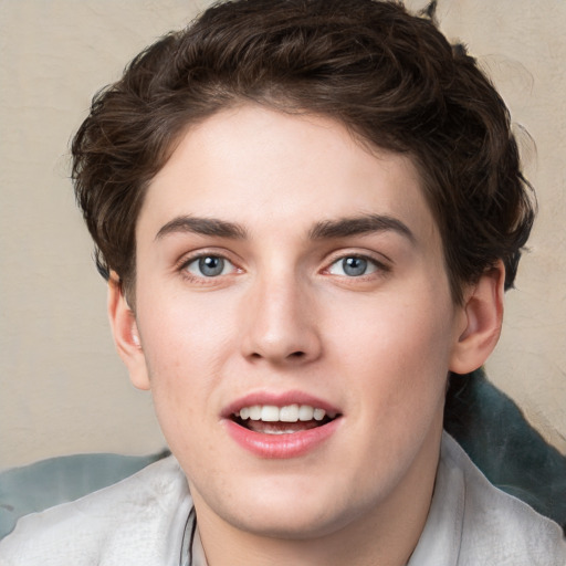 Joyful white young-adult male with short  brown hair and blue eyes