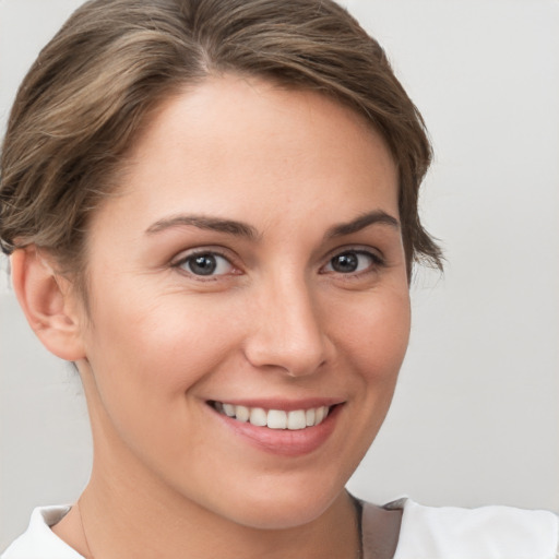 Joyful white young-adult female with short  brown hair and brown eyes