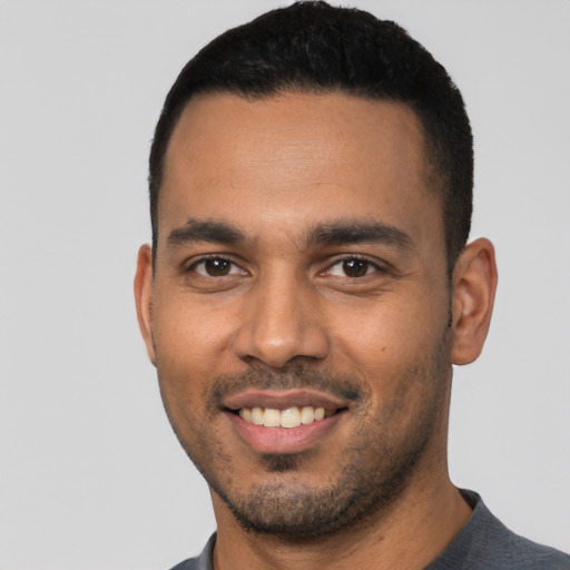 Joyful latino young-adult male with short  black hair and brown eyes