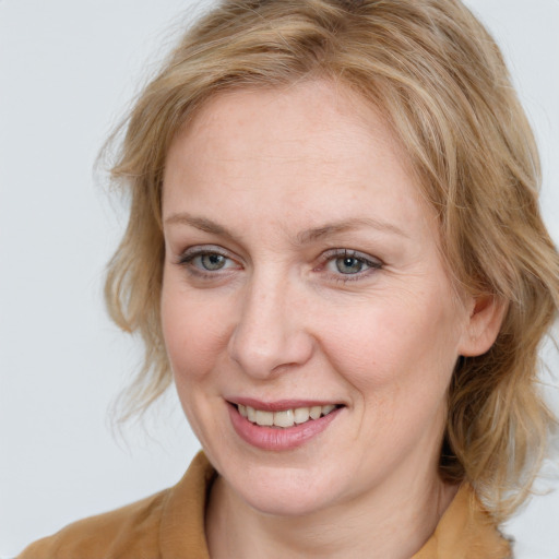 Joyful white adult female with medium  brown hair and blue eyes